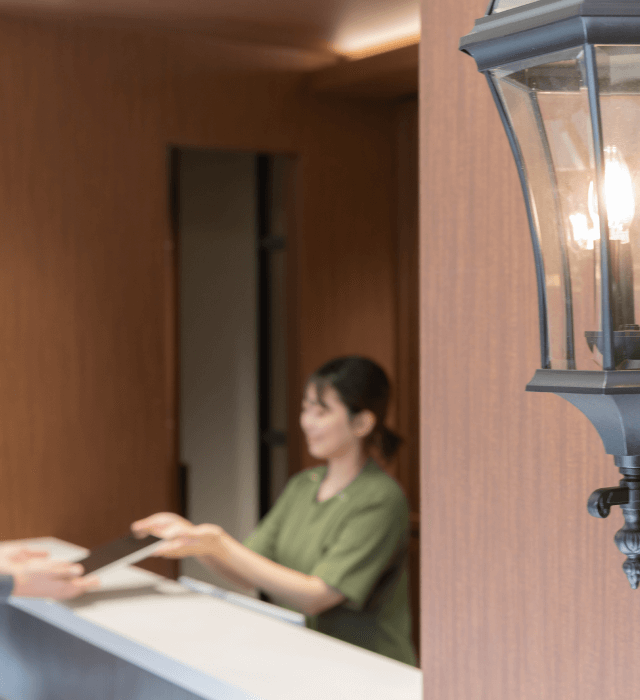 受付カウンターで患者に書類を渡す医療スタッフ