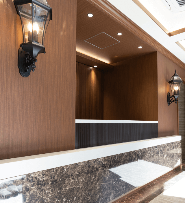 木目調の壁とランタン型ライトが設置された、落ち着いた雰囲気の受付カウンター